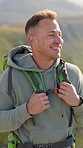 Backpack, hiking and laughing with man outdoor in nature for adventure, hobby or journey. Tourism, trekking and wellness with funny hiker person in mountain location for break, trip or vacation