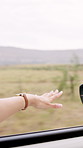 Hand, window and driving in car on road tip, wind and playful with sightseeing in countryside. Person, vehicle and memory with freedom, journey or highway for travel with transportation on vacation