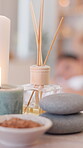 Incense, candle and hot stones for therapy at spa for fragrance, aromatherapy and luxury skincare. Person, relax and equipment setup for salt scrub, aroma oil and candlelight for self care at retreat