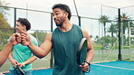 Fist bump, sports and people with padel on tennis court for practice, match or workout together. Happy, fitness and team of athletes with greeting for support in game, training or exercise outdoor.