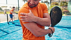 Sports, padel and man on tennis court with shoulder pain, injury or accident for match. Sore, fitness and male athlete with racket for arm muscle sprain, torn ligament or inflammation outdoor.