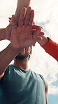 Outdoor, sports and hands stack of people for teamwork, collaboration and motivation for workout. Applause, blue sky and low angle of athletes together for support for training, exercise and fitness