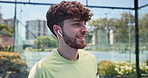Fitness, man outdoor and listening to music for sports game, padel tournament or skill development. Happy, person or athlete on tennis court with earphones, online radio or getting ready for workout.