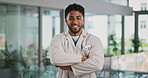 Face, doctor and happy man with arms crossed as healthcare consultant, wellness or laugh. Portrait, confident employee and medical professional with pride, funny person or about us in hospital in UAE