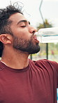 Man, fitness and drinking water with bottle on padel court for hydration, recovery or rest. Thirsty, male person or athlete for mineral liquid with beverage for natural sustainability, sport or break