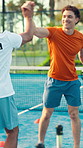 Coaching, padel and high five with man on court for competition training, support and club. Challenge, personal trainer and tennis player with people on outdoor turf for sports and motivation