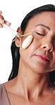 Woman, face roller and relax in studio with massage for lymphatic drainage, beauty and dermatology. Calm, mature person and cosmetic tool for facial tension, skincare or wellness on white background.