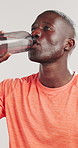 Black man, fitness and drinking water with bottle for hydration on a white studio background. Active, male person or African model with thirst, mineral liquid or aqua beverage for break or recovery