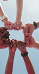 Group, fist bump and low angle for fitness, outdoor and sky for motivation with training routine. People, huddle and team with synergy, running club and exercise for wellness with community in summer