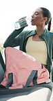 Woman, drinking water and fitness in city with car, electrolytes and hydration for mineral benefits. Person, break and bottle with liquid for wellness, detox or bag in vehicle for exercise routine