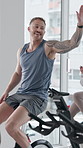 Spin class, high five and man on bike, exercise or celebration for fitness goals, happy and training. Gym, endurance and people on machine for workout routine, achievement and cycling for wellness