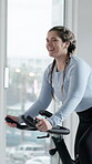 Spin class, cycling and woman with bike, happy and training for body strength, wellness and exercise. Gym, endurance and person on machine for workout routine, mobility and active for fitness goals