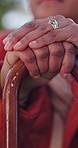 Hands, cane and elderly person in park, outdoor or peace of patient in assisted living. Nature, retirement or senior woman with disability, backyard and calm in old age, walking stick or nursing home