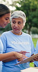 Woman, volunteer and talk with clipboard at park for donation, point and writing with social responsibility. People, team and help with checklist, review or discussion with sign up for charity event