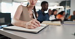 Notebook, hands and woman in classroom for studying, education or assignment at university. Writing, pen and female student learning for college test or exam in lecture with scholarship at school.