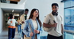 Man, woman and talk at college with students, smile and walk with story at campus for education. People, friends and listen with chat, gossip or discussion in hallway with scholarship at university