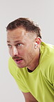 Tired, athlete and man with earphones, studio and listening to music with subscription for exercise. White background, exhausted and person with tech for entertainment, breathing and happy with audio