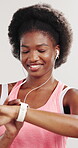 Black woman, earphones and smart watch in studio for fitness, dancing and exercise preparation. Happy person, rhythm or check time for workout break, wellness and streaming music on white background.