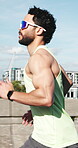 Running, fitness and health with man in city for challenge, training and race performance. Cardio, exercise and sports athlete with male person outdoors for runner practice, wellness and workout