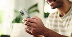 Typing, home and hands of man with phone on sofa for social media, online chatting and internet on weekend. House, living room and person on smartphone for mobile app, connection and networking