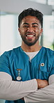 Face, surgeon and man with smile, arms crossed and worker with confidence, career ambition or pride. Happy person, medical service and doctor in hospital, healthcare facility and professional