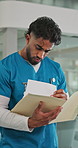 Nurse, man and walking in hospital with folder for patient info, medical research and test results. Healthcare worker, person or reading with documents for appointment, diagnosis referral and advice.