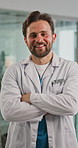 Face, doctor and man in hospital, arms crossed and smile with confidence, career ambition or pride. Happy person, medical service or surgeon in clinic, healthcare facility and professional with trust