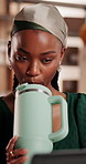 Drink, laptop and black woman in small business for shipping, inventory management or hydration. Computer, metal flask and ecommerce entrepreneur with cup for refreshing liquid in logistics office