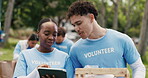 Volunteer, discussion or people in nature with tablet, group or package checklist in eco friendly project. Team, coordination or NGO in park with tech, inventory track or guidance in charity donation