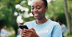 Laughing, phone and volunteer woman outdoor for charity, community outreach or donation update. App, funny and typing with happy person in park for social media post of ngo or non profit mission