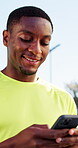 Fitness, typing or black man outdoor with smile, online communication or post reaction on workout break. Sport, happy or athlete in park with phone, message or social media update in exercise rest.