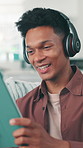 Laugh, headphones and tablet with man on sofa in home for comedy, streaming service and relax. Online movie subscription, connection and film app with person in living room of apartment for tech