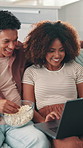 Couple, popcorn and laptop on sofa for date, love or bonding together in home. Snacks, subscription and man on couch with woman and romance for streaming film, online video or series in house