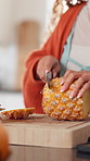 Hands, cutting and woman with pineapple, home and organic ingredients with vitamins. Knife, fruit and person in kitchen, healthy snack and nutrition with vegan food, chopping board and diet meal
