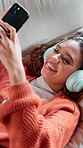 Woman, relax and phone with headphones at house for social media, streaming and listening to music. Above, person and mobile to download playlist, podcast audio and app subscription for entertainment