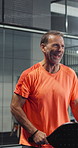 Fitness, laughing and padel with man on court competition, joy or tournament satisfaction. Exercise, funny and tennis with happy mature person at sports venue, excited for game, match or practice