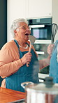 Cooking, singing and happy with old couple in kitchen for bonding, support and connection. Karaoke, meal prep and music with senior man and woman in home for romance, entertainment and relationship