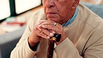 Walking stick, thinking and hands of senior man on sofa for reflection, nostalgia and memory in home. Retirement, living room and elderly person with disability and cane for remember, lonely and sad