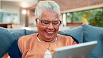Tablet, laugh and senior woman on sofa in home reading blog post for news in living room on weekend. Relax, retirement and elderly female person with digital technology for online headline in house.