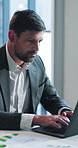 Business, man and typing with laptop in office for accounting, finance report and statistics. Male person, pc and graphs on documents with data analysis, financial evaluation and analytics for audit