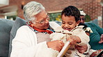 Book, playing or teddy bear with boy and grandmother on sofa in living room of home for bonding. Family game, laughing or love with children and senior people in apartment for break or visit