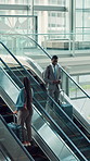 Escalator, airport and business people with luggage, greeting and travel with phone. Suitcase, international trip and employee talk with mobile for flight schedule, commute or corporate journey above