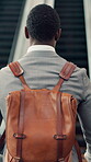 Backpack, escalator and man walking with in airport for international business trip or travel. Commute, departure and luggage with employee person in terminal for flight or opportunity from behind