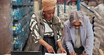 Supply chain, documents and women in warehouse, laptop and teamwork with shipping schedule. People, computer and employees in workplace, cooperation and report for logistics, talking and distribution