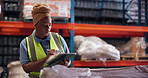Black woman, tablet and writing at warehouse, logistics and inventory management job with checklist. African person, tech and notes for supply chain career, app and shipping at distribution plant