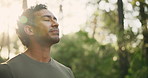 Athlete, man and breathing for fitness in nature for exercise, training and morning routine. Bokeh, male person and thinking with lens flare, fresh air and runner break of recovery wellness in forest