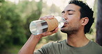Drinking water, exercise and hiking with happy man in forest for adventure, hobby or travel. Bottle, fitness and hydration with hiker person outdoor in nature for holiday, sightseeing or tourism