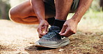 Man, hands and tying with shoes in nature for hiking, fitness preparation or outdoor run in forest. Closeup, male person or runner getting ready with tie, sneaker or laces for trekking or exercise