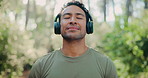 Breathing, headphones and man in forest for fitness, mindfulness or audio for zen. Athlete, relax and person with meditation music in nature, streaming radio or exercise for health on break with calm