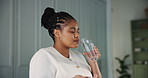 Glass, drinking water and pills with black woman in kitchen of home for detox drinks, medicine and health. Supplements, wellness and treatment with person in apartment for liquid and beverage